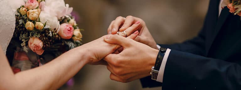 Hombre poniendo alianza a su mujer en el matrimonio